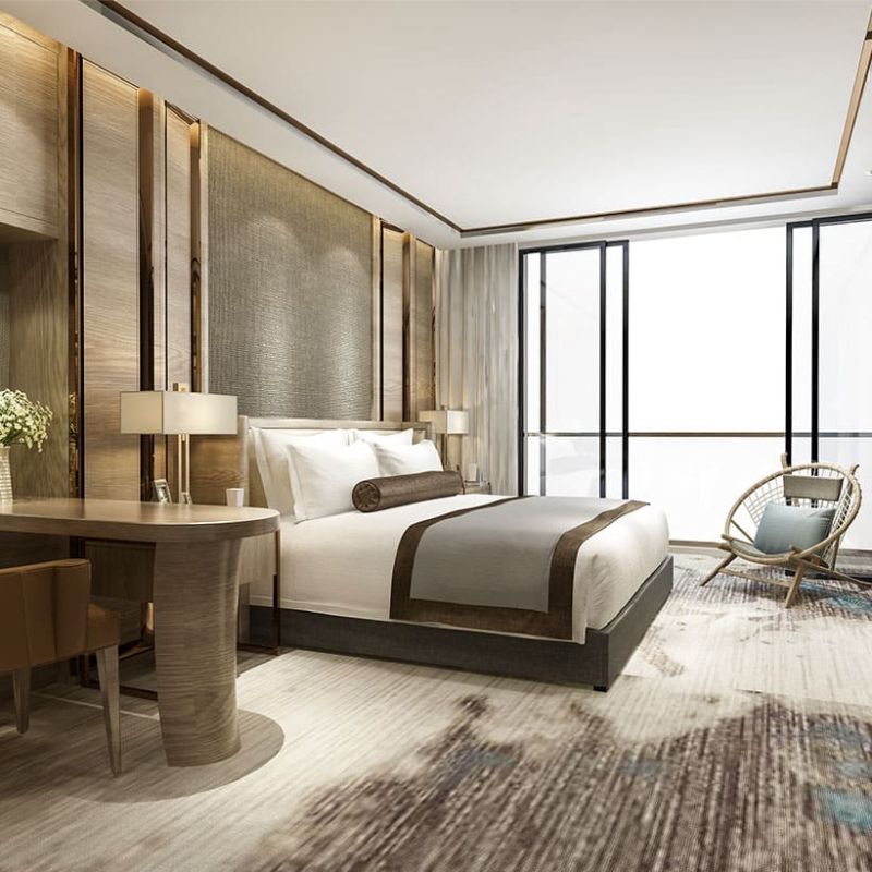 Modern eingerichtetes, helles Hotelzimmer mit stilvoller Holzverkleidung, Doppelbett und Sitzbereich – perfekt gereinigt für höchste Ansprüche