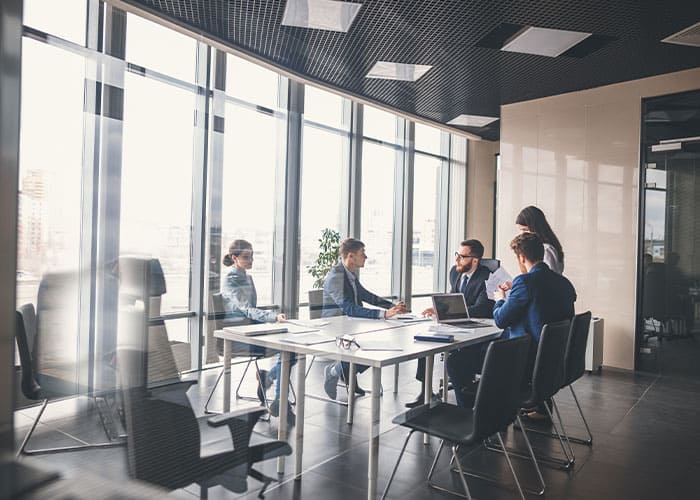 Business-Meeting in einem modernen Konferenzraum mit großen Fenstern – Teamarbeit, Planung und Kundengespräche bei Glanz & Glorie Hotel Service